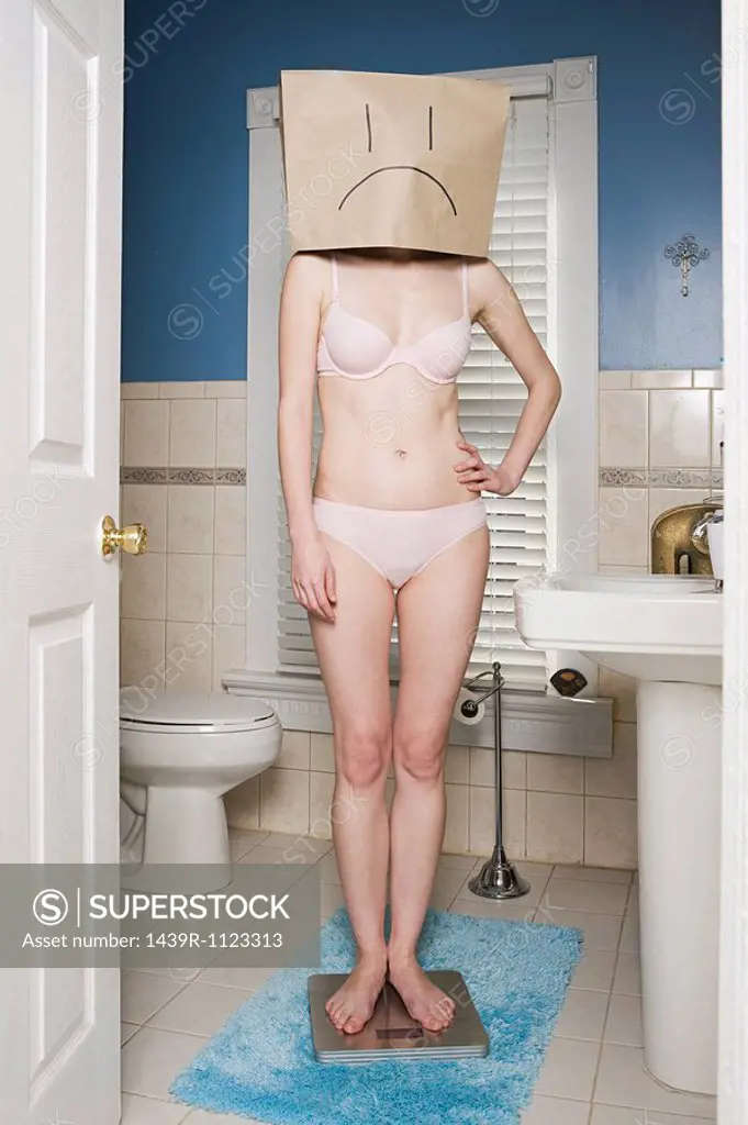 Young woman with paper bag with sad face over head
