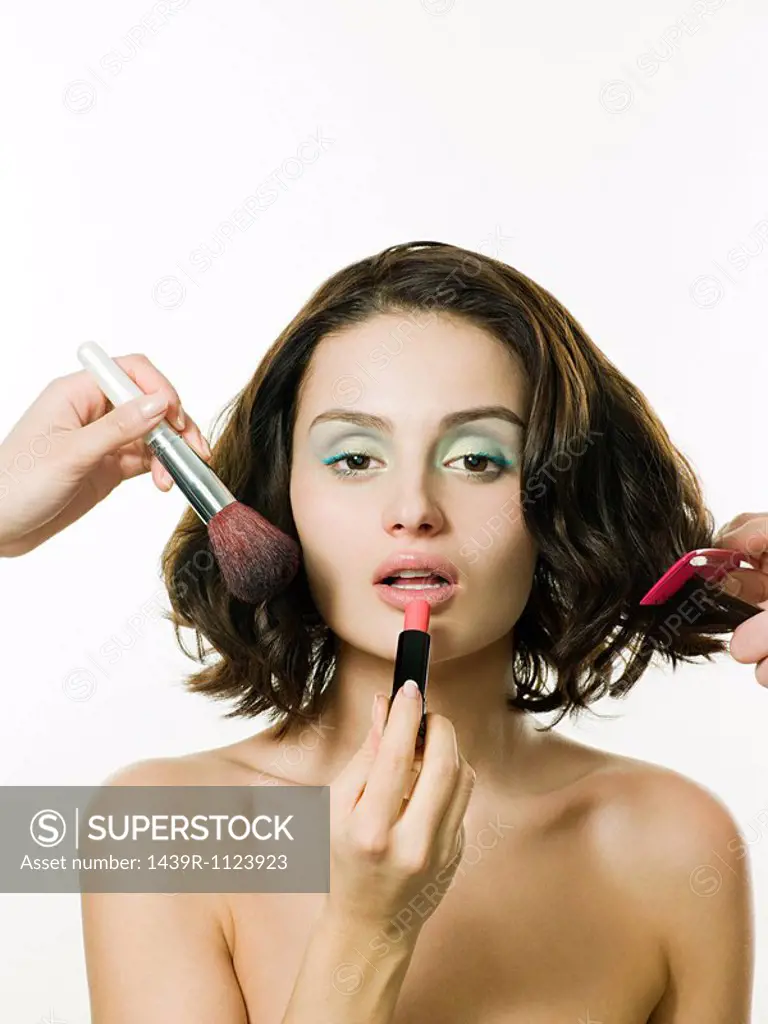 Young woman having hair and makeup done