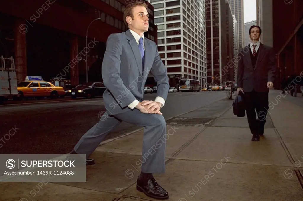 Businessman stretching on street