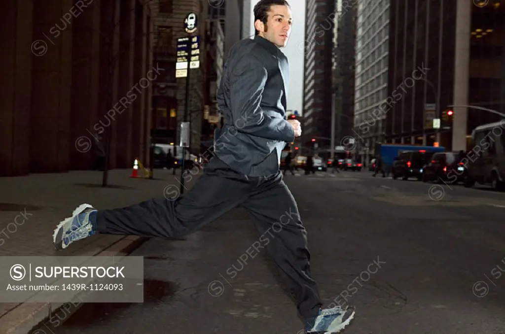 Businessman running through city