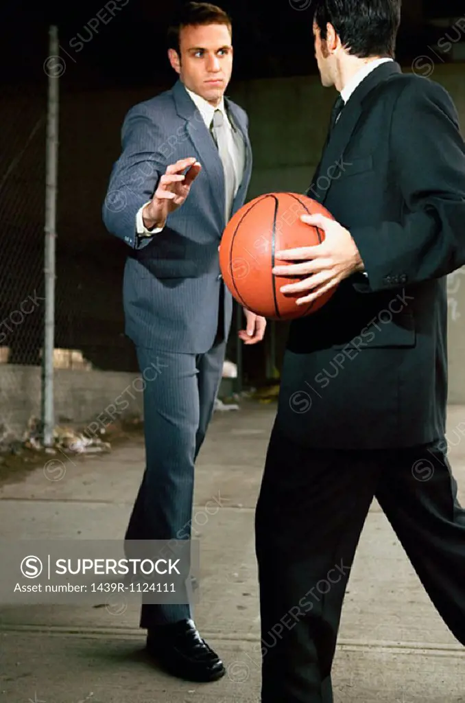 Businessmen playing basketball