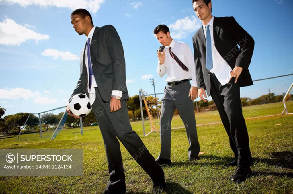 Businessmen on football pitch