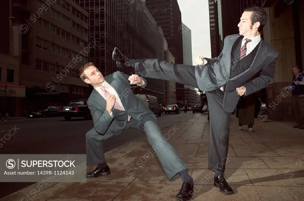 Businessmen fighting in street