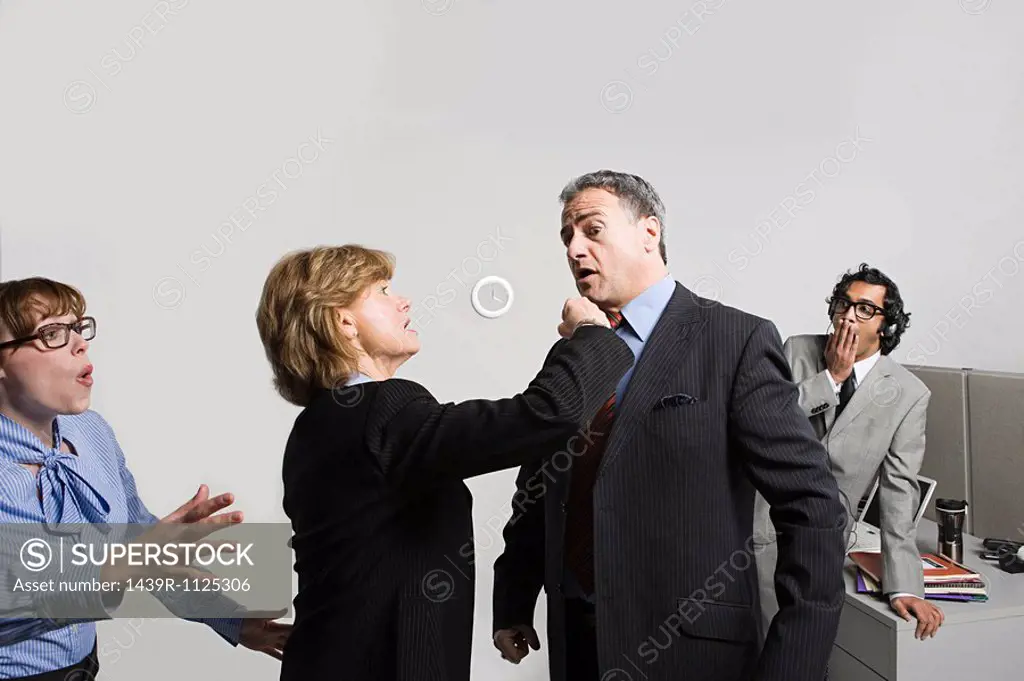 Businesswoman punching businessman