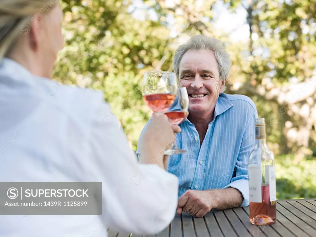 Couple toasting with wine outdoors