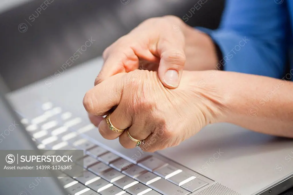 Laptop and woman with pain in hand