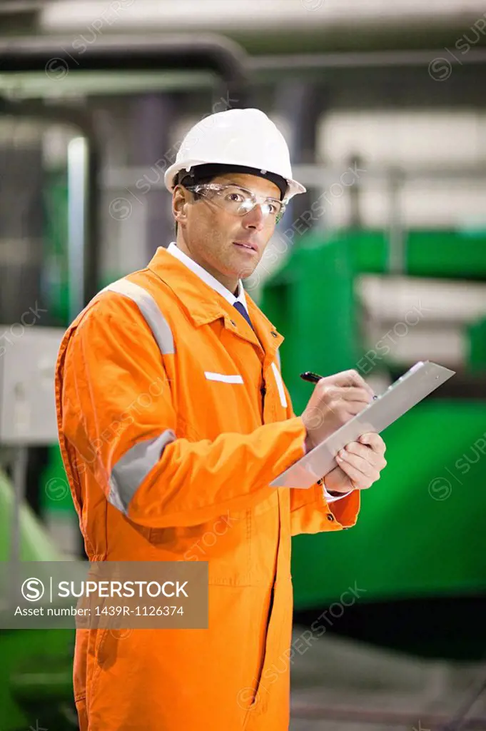 Engineer in factory with clipboard