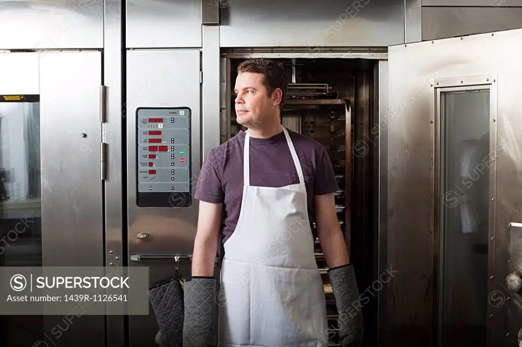 Male chef standing in front of oven