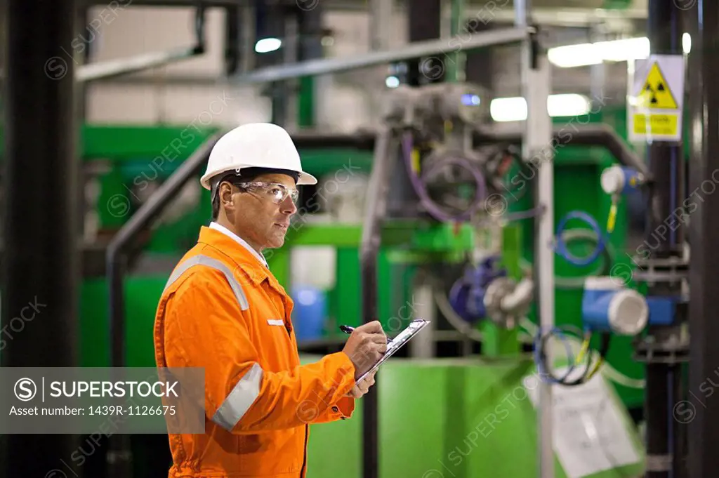 Engineer inspecting machinery in factory