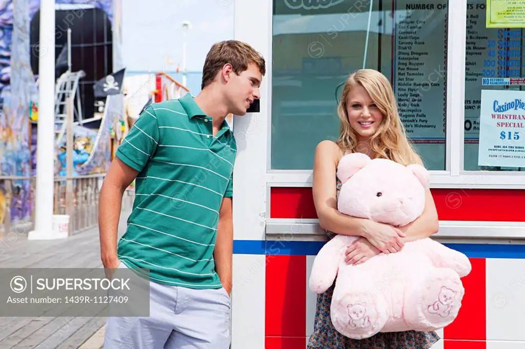 Teenage couple at pier with teddy bear