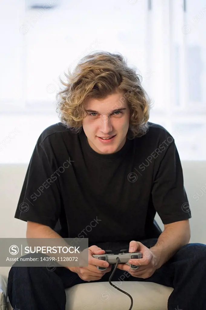 Teenage boy playing on games console