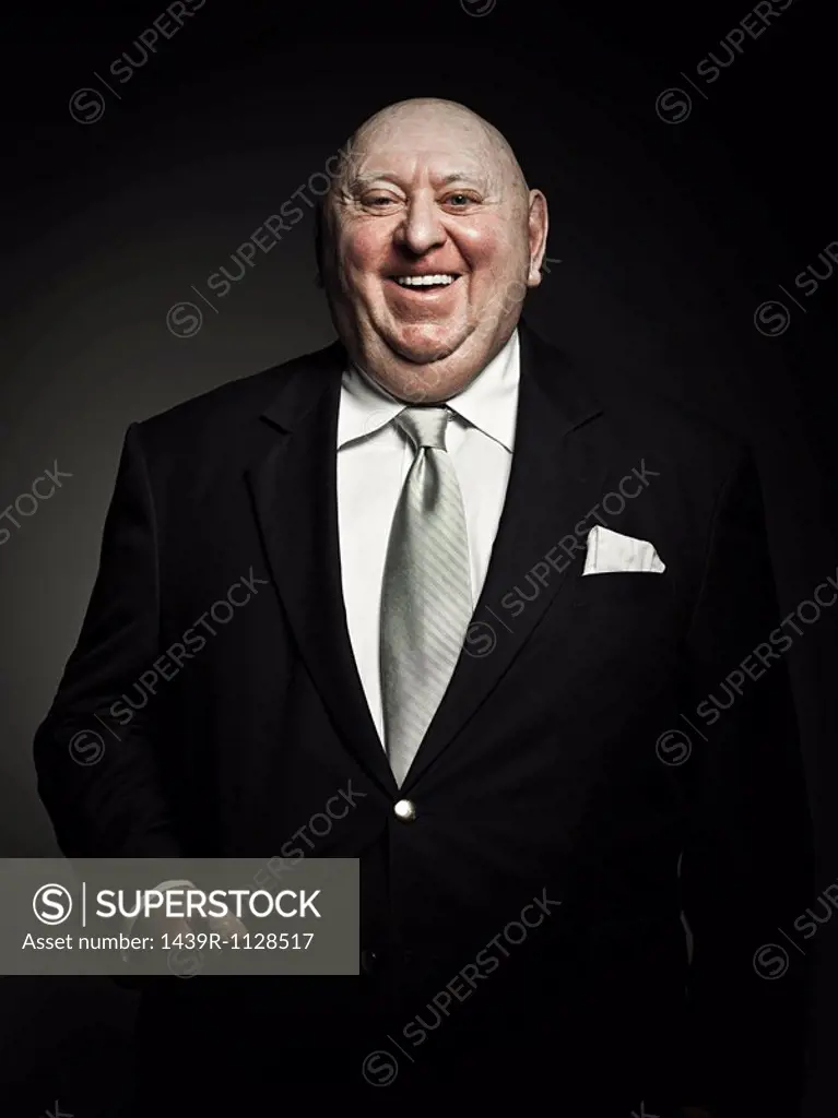Studio portrait of cheerful senior man laughing