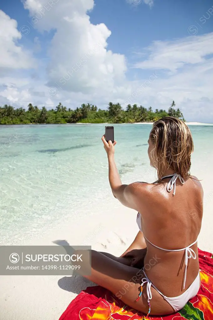 Woman taking picture, Medahutthaa Island, North Huvadhu Atoll, Maldives