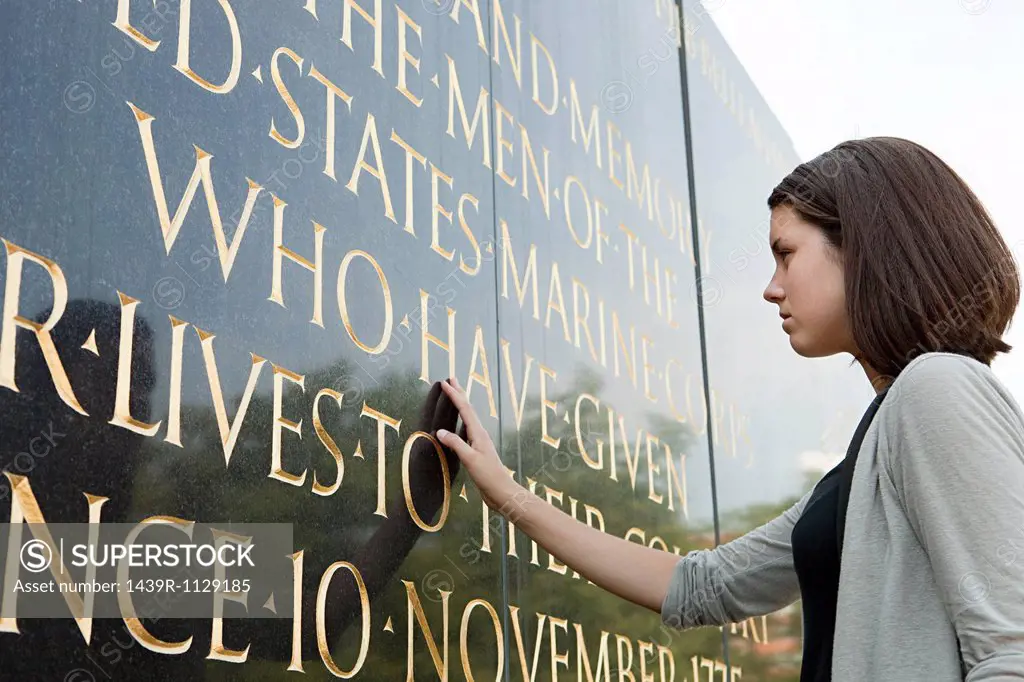 Girl looking at inscription of marine corps war memorial