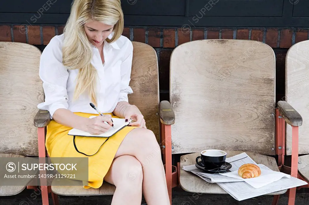 Woman writing outside coffee shop