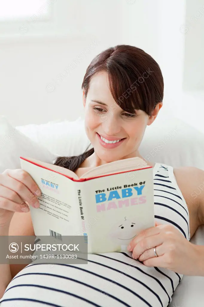 Pregnant woman with baby name book