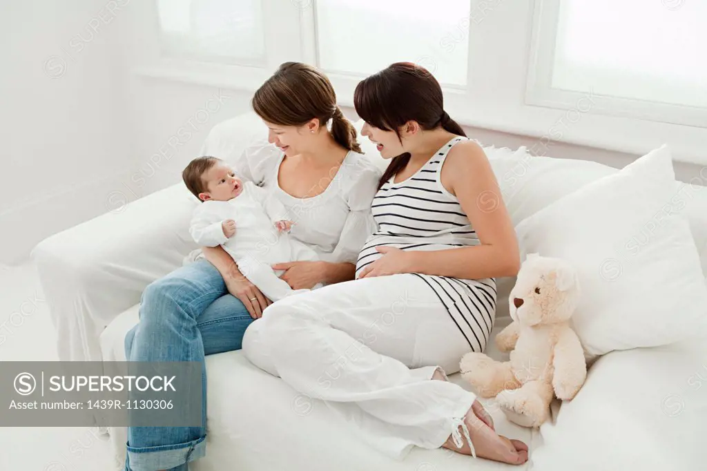 Mother with baby girl and pregnant friend