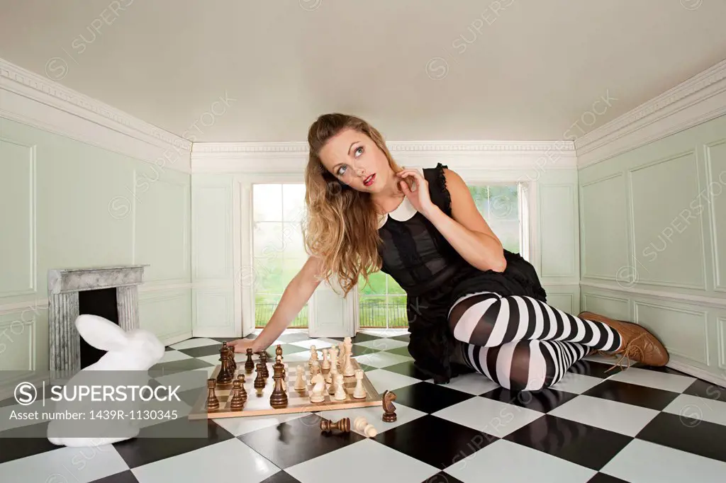 Young woman playing chess with rabbit