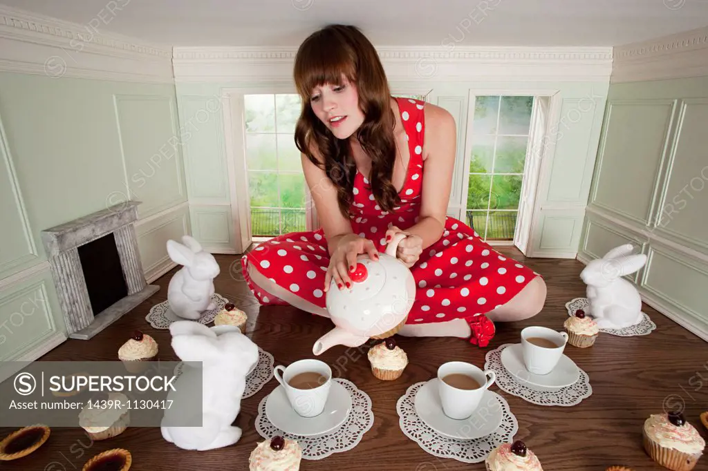 Young woman having tea party in small room