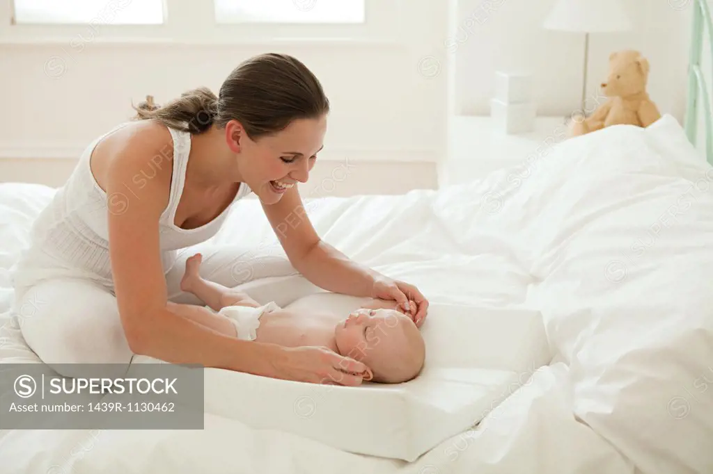 Mother with baby son on changing mat