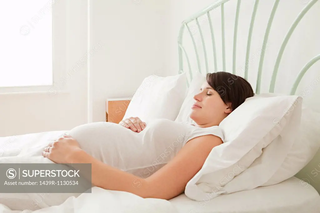Pregnant woman asleep in bed