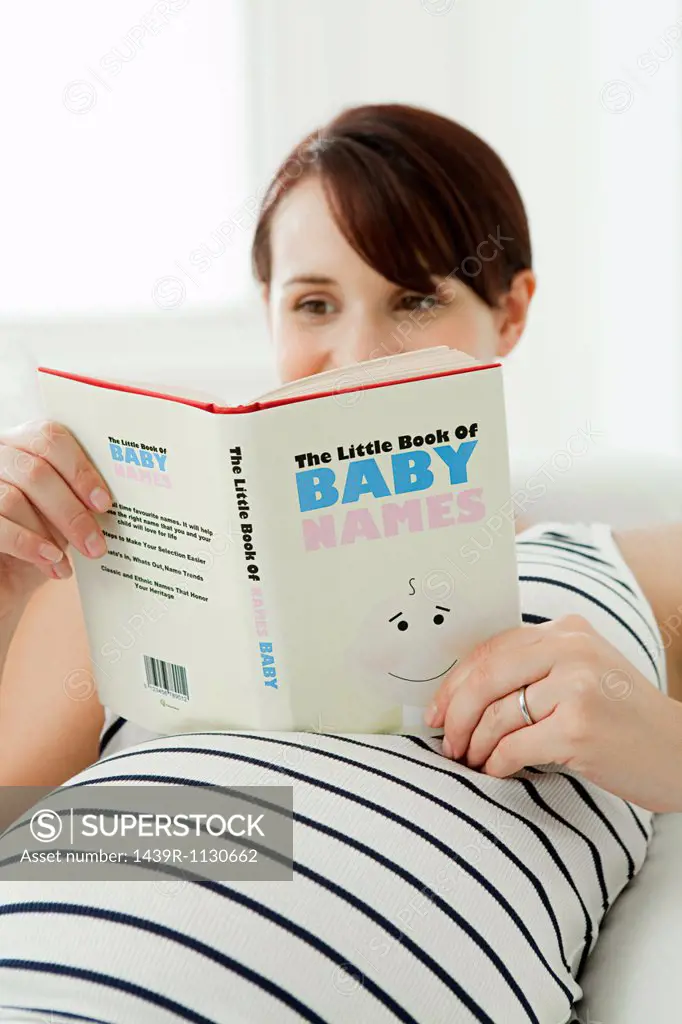 Pregnant woman with baby name book