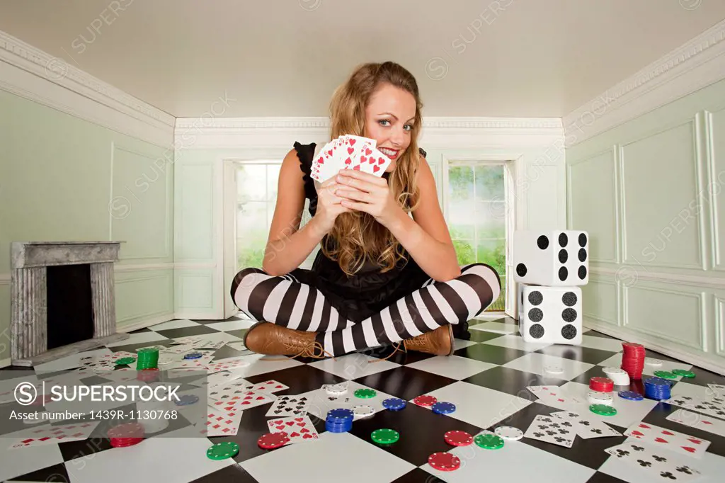 Young woman in small room with playing cards and dice