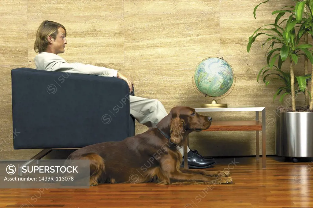 Businessman and his dog infront of a globe