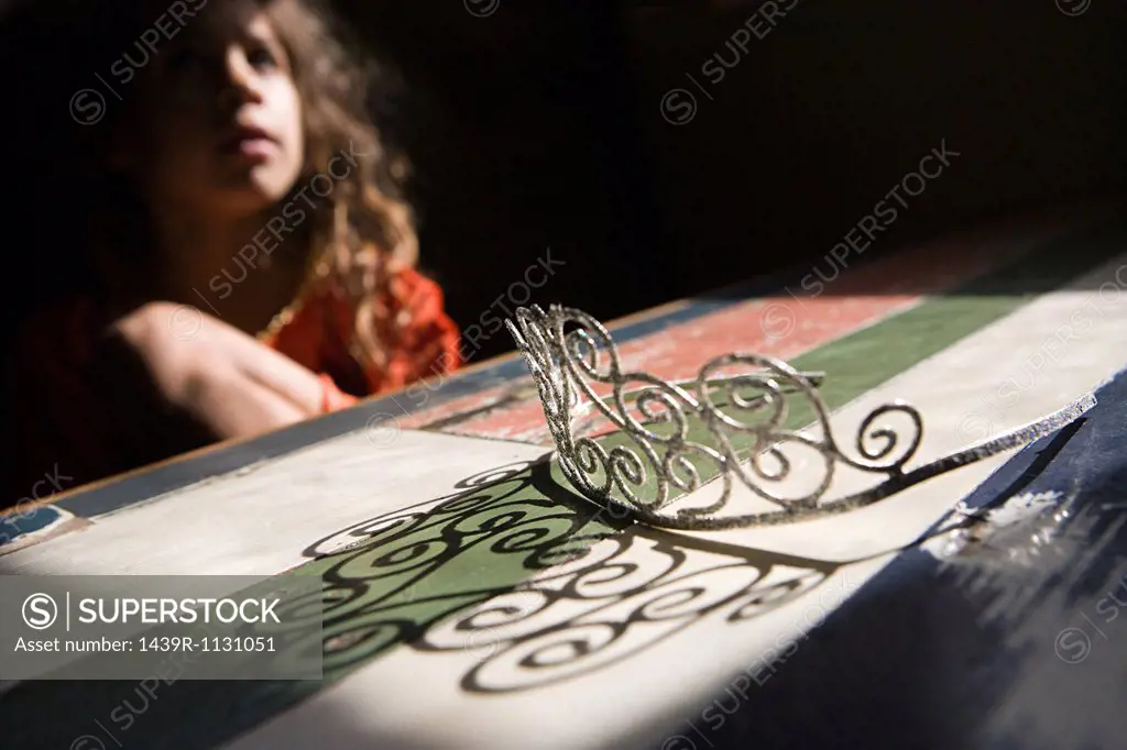 Girl looking at tiara on table