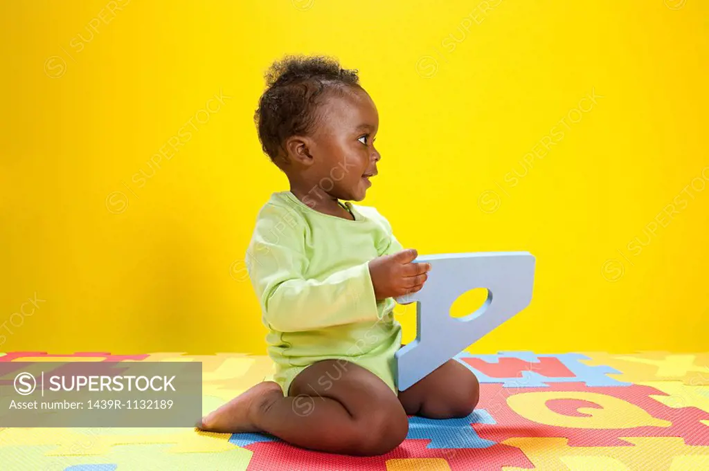Baby boy playing with toy alphabet letters