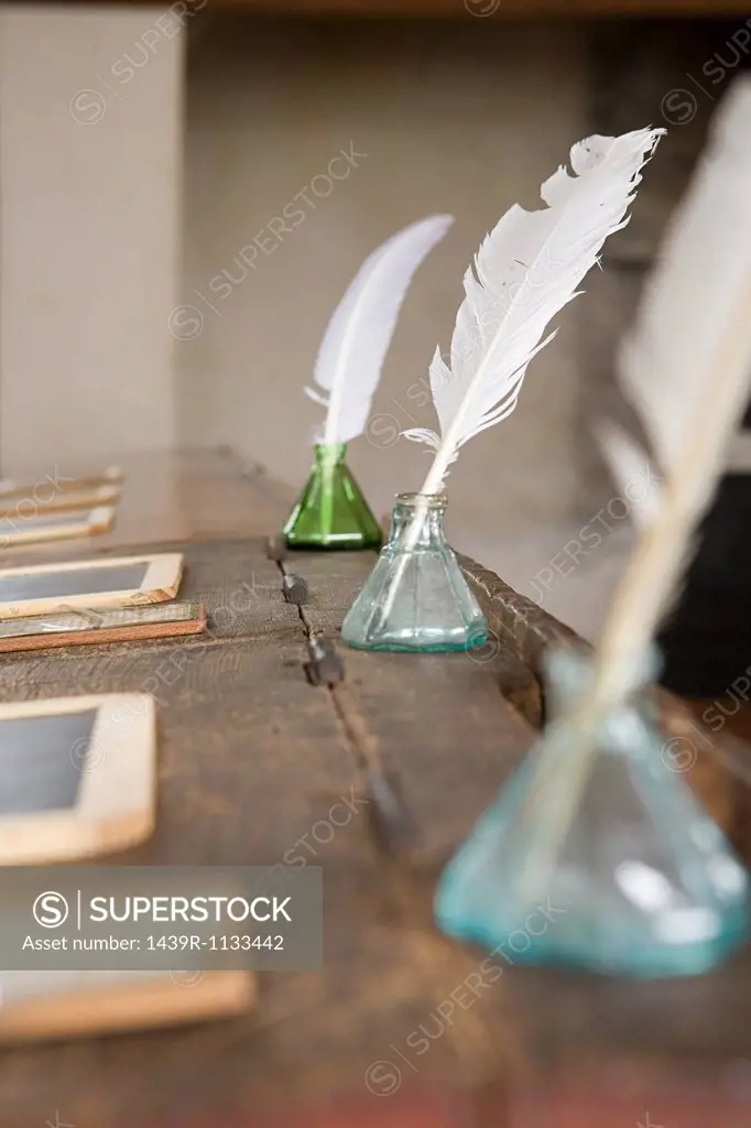 Quill pens and inkwells on old fashioned desks