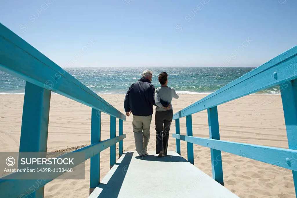 Rear view of couple on beach walkway