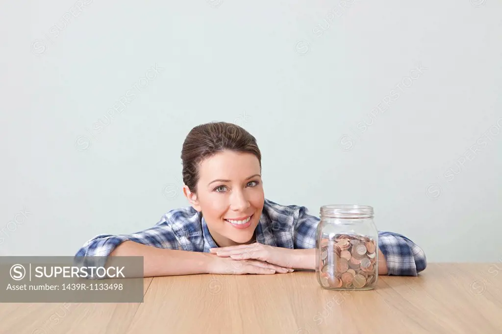 Young woman with jar of coins