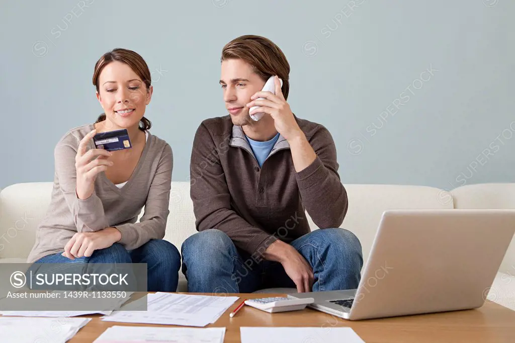 Young couple using computer and doing paperwork