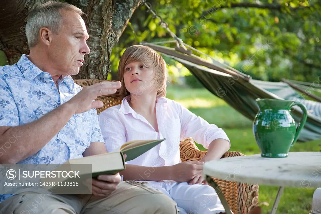 Father and son with book, in conversation