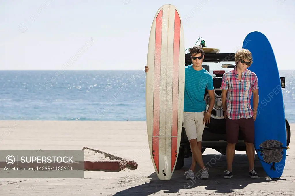 Two young men at coast with surfboards