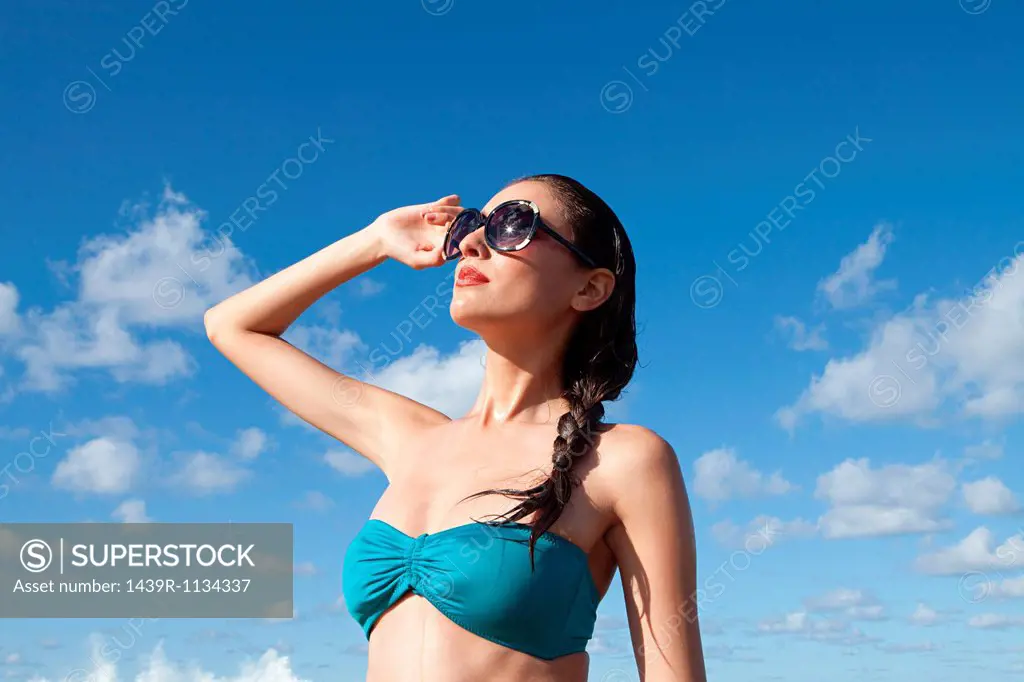 Woman wearing sunglasses shielding eyes