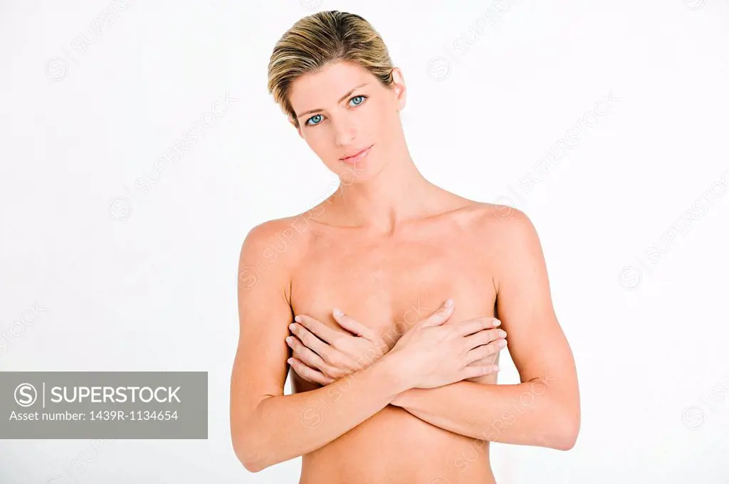 Portrait of young woman covering breasts