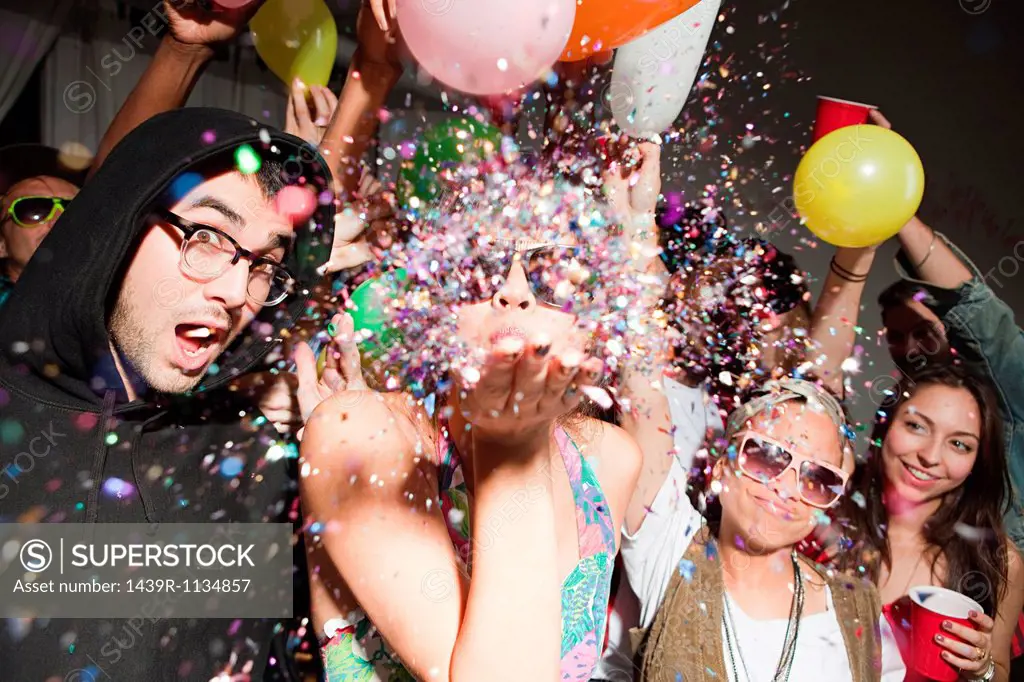 Woman blowing glitter at party