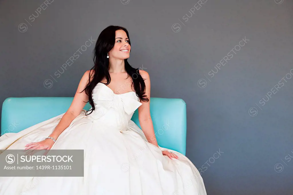Young woman wearing white wedding dress, studio shot