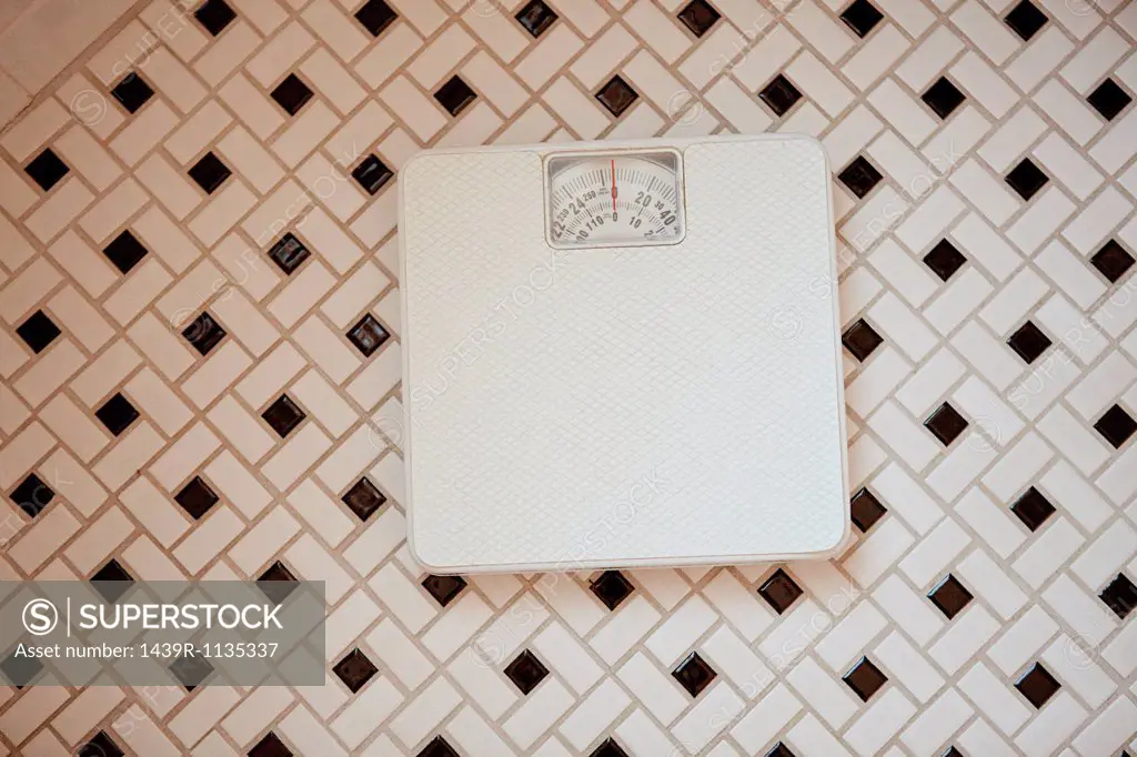 Bathroom scales on tiled floor