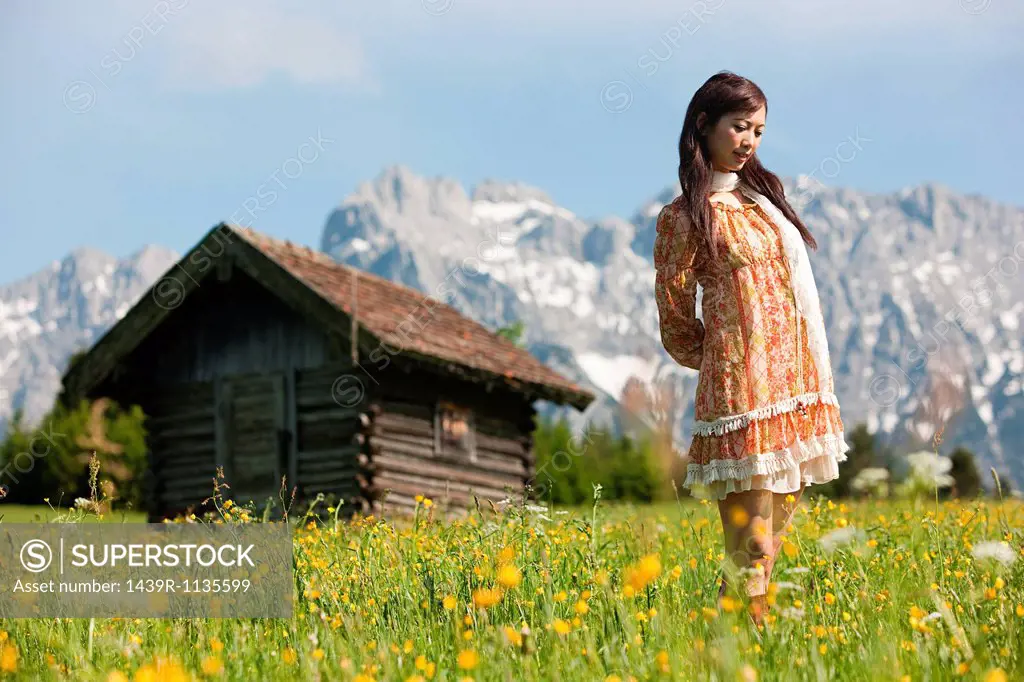 Woman in meadow with Bavarian Alps in background, Germany