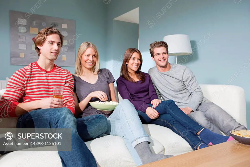 Two young couples watching television