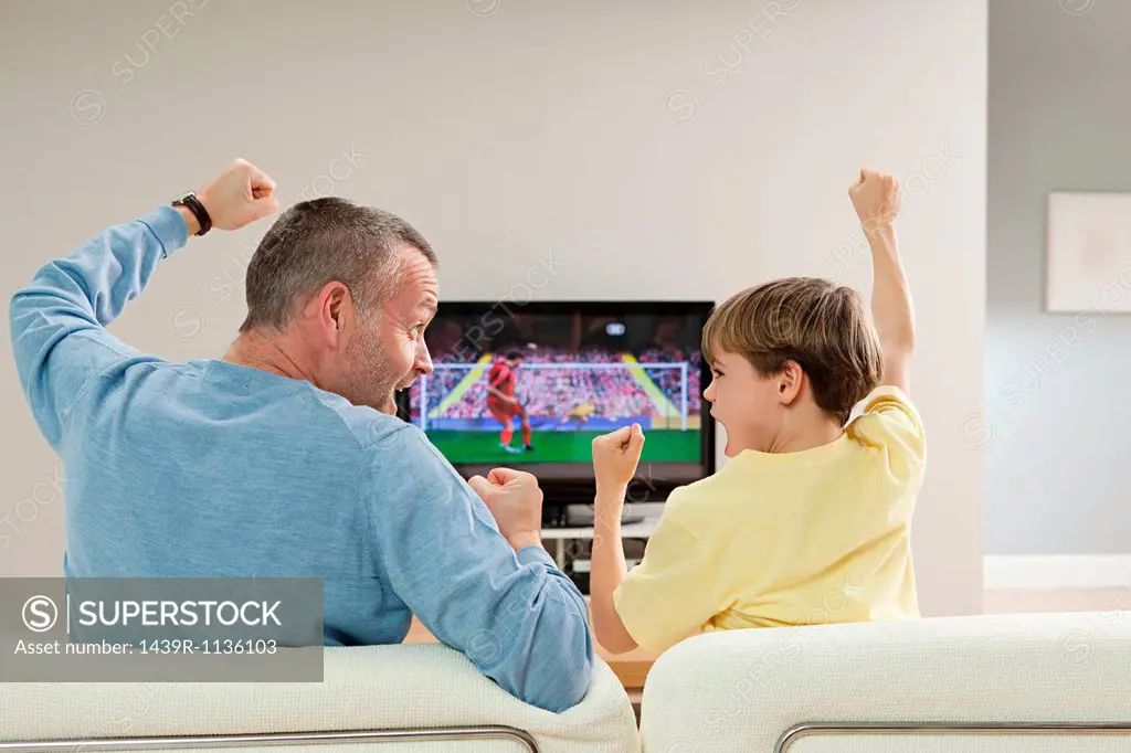 Father and son watching football on television