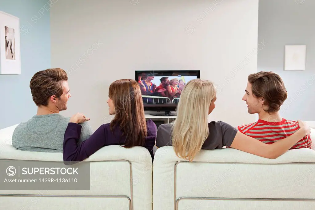 Two couples watching television