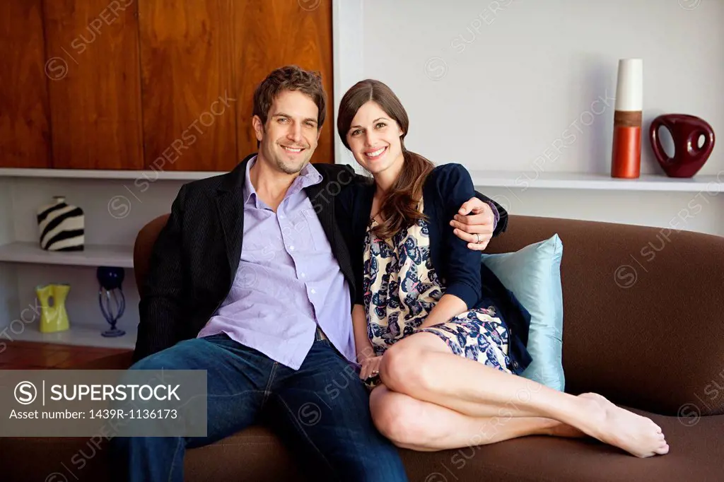 Couple sitting on sofa, portrait