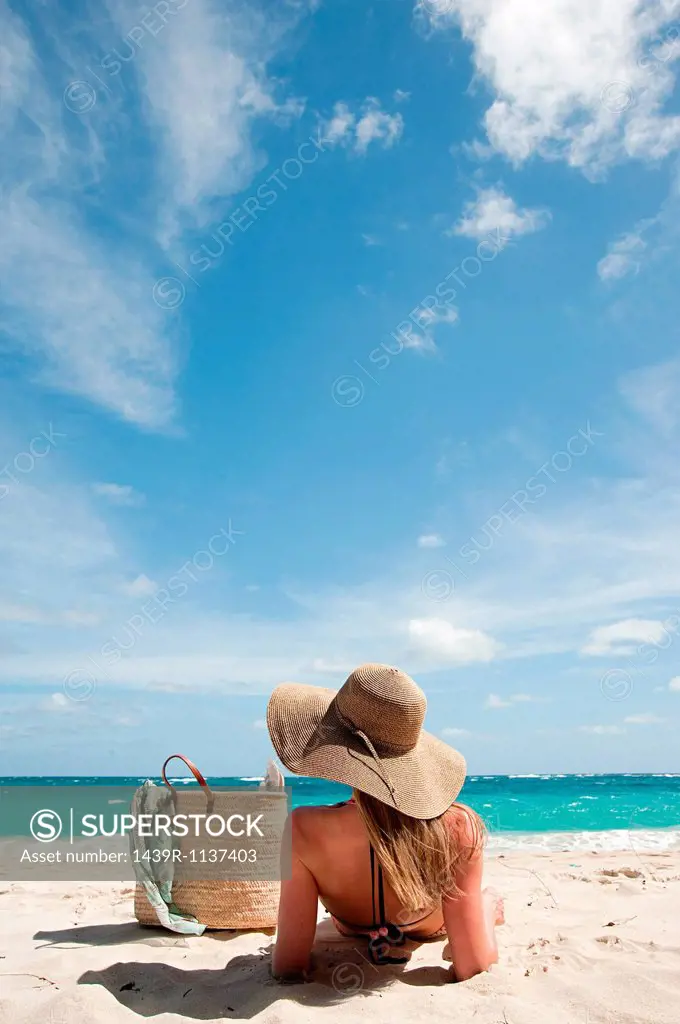 Woman lying on sandy beach, Mustique, Grenadine Islands
