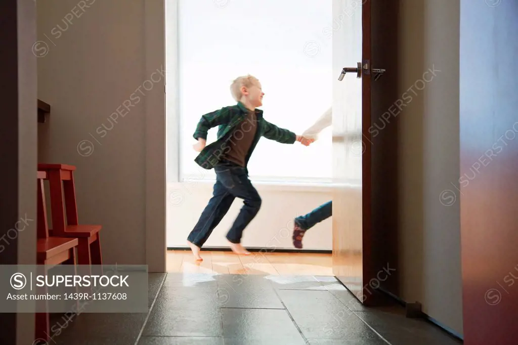 Two children running past doorway