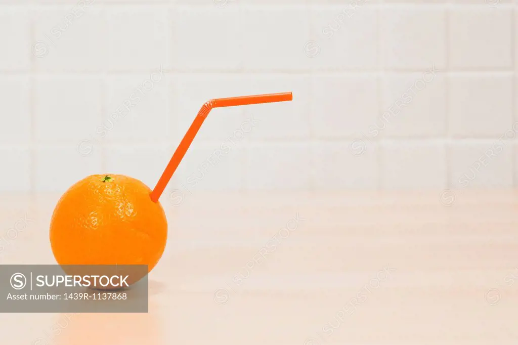 Orange with drinking straw sticking out