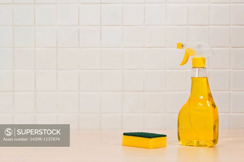 Bottle of yellow cleaning fluid and cleaning sponge